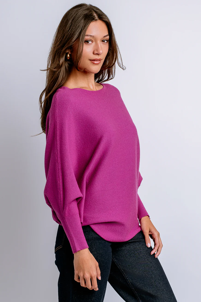 Woman wearing a pink sweater against a plain background
