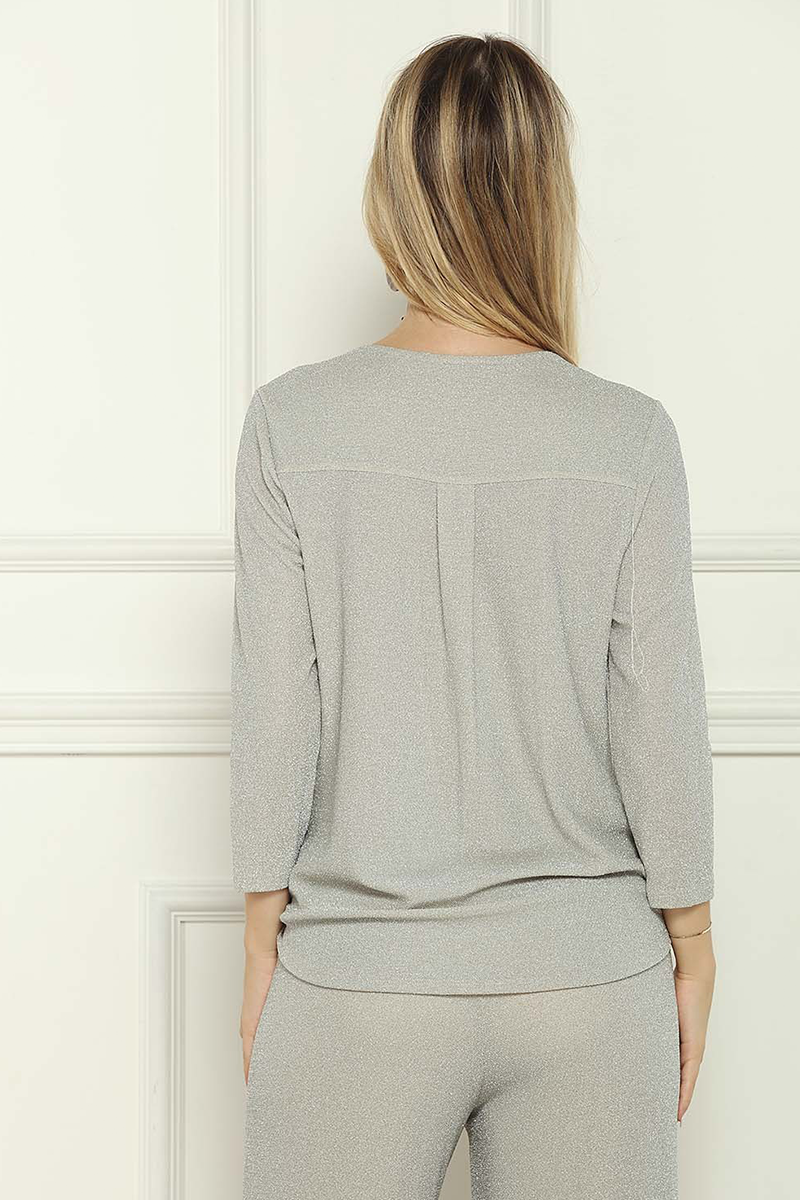 Woman wearing a light gray outfit against a white background