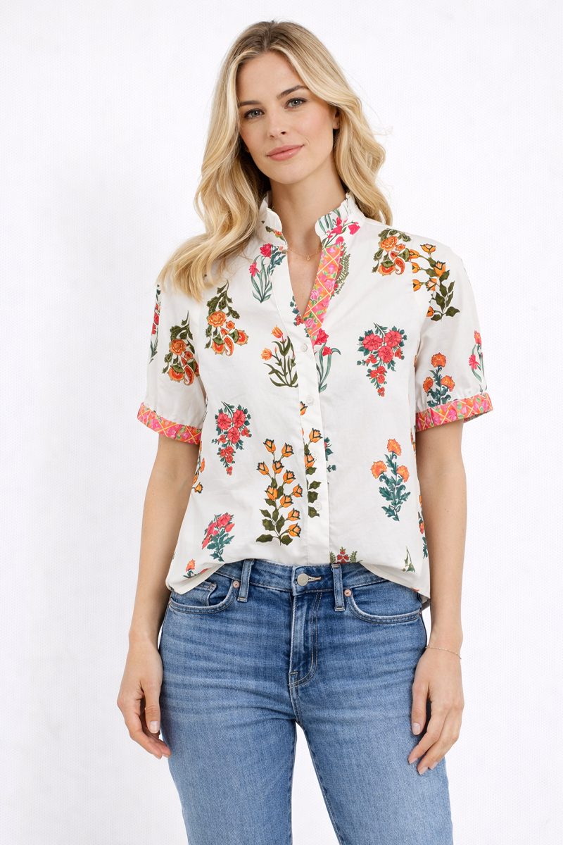 Woman wearing a floral blouse and blue jeans on a white background