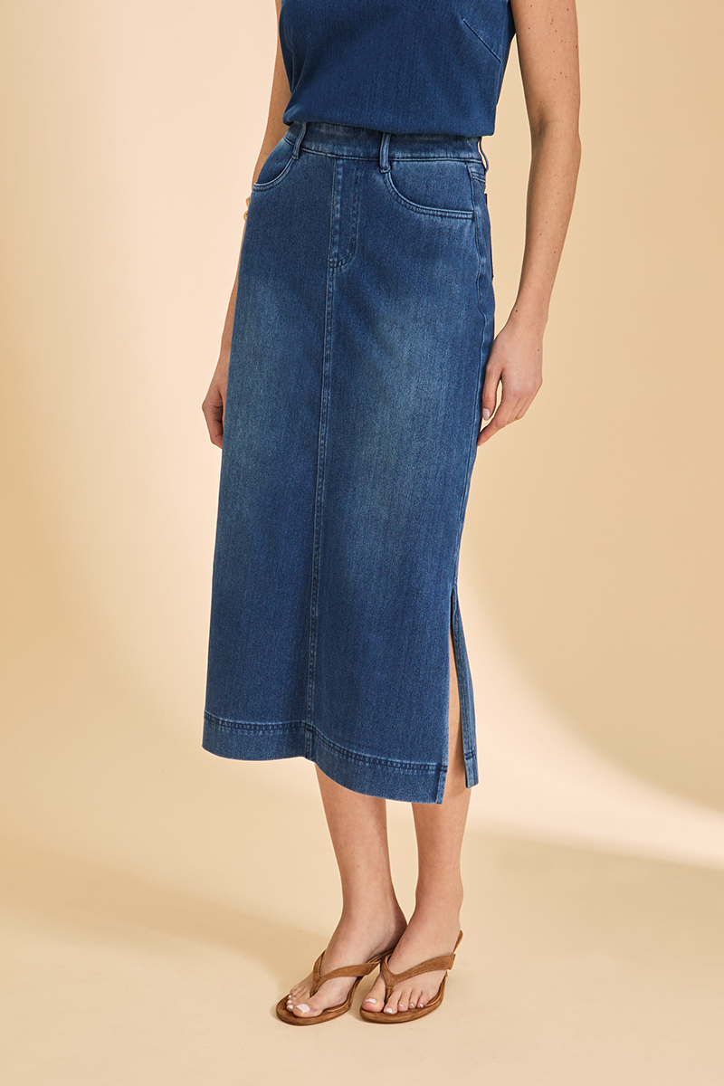 Person wearing a blue denim skirt on a beige background