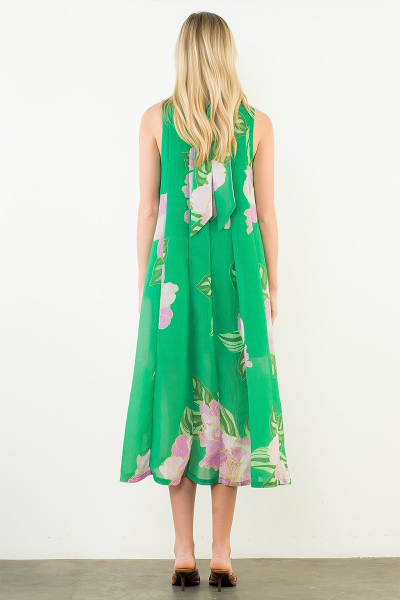 Woman wearing a green floral dress against a white background