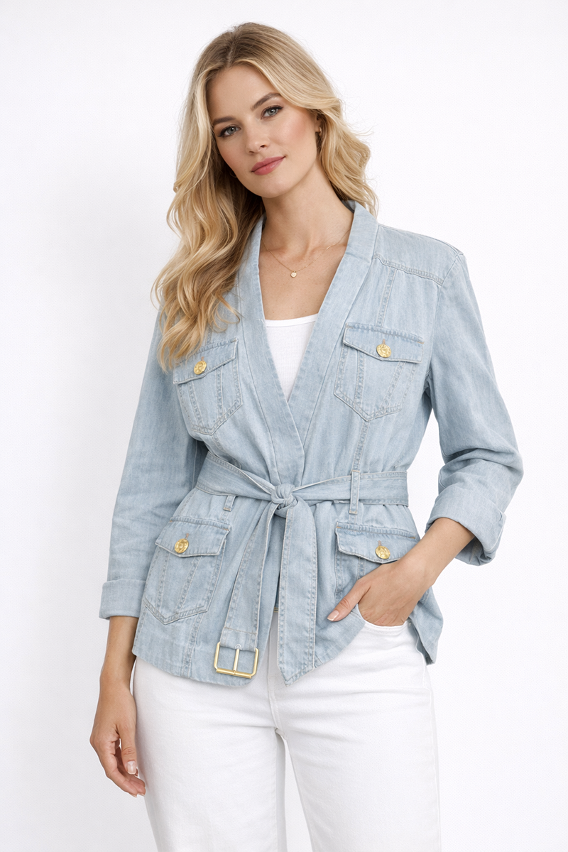 Woman wearing a light wash denim blazer with gold buttons on a white background
