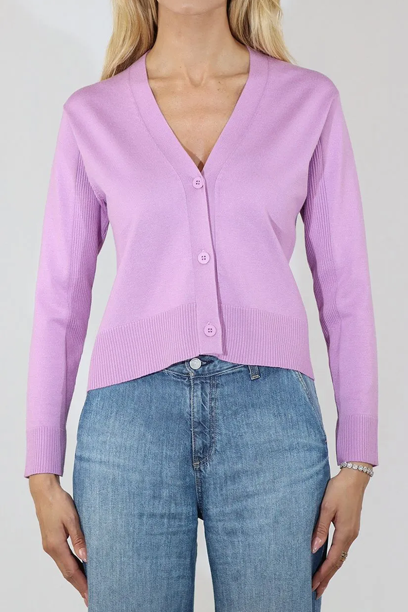 Person wearing a high-low light purple cardigan and blue jeans on a plain background
