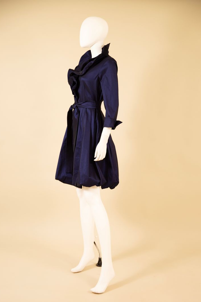 Navy blue dress on a mannequin against a beige background