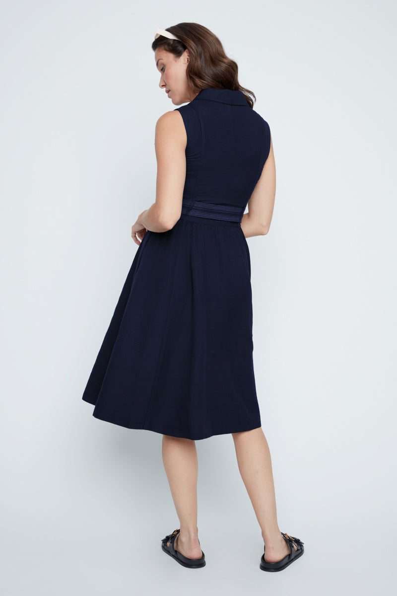Woman wearing a navy dress on a white background