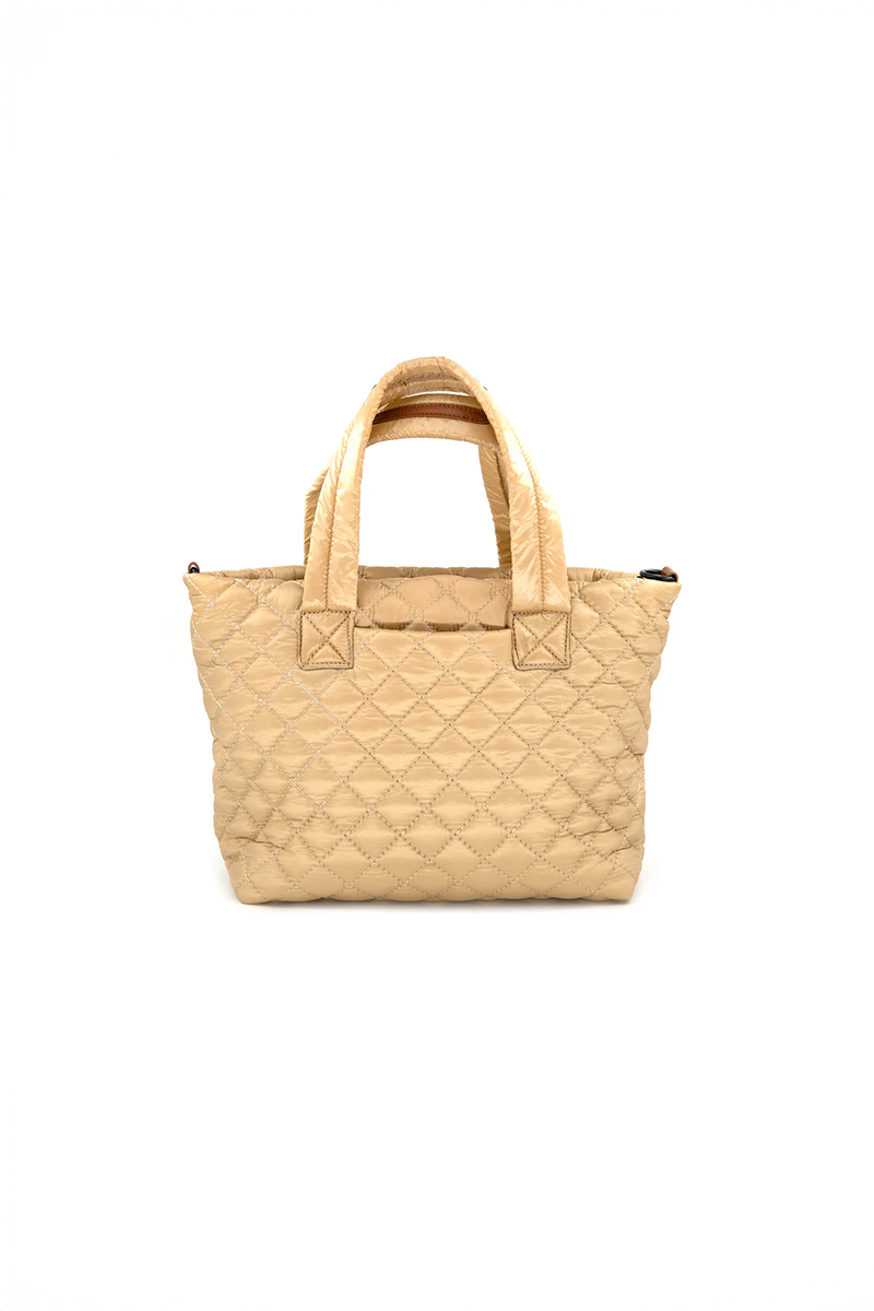 Beige/gold quilted handbag on a white background