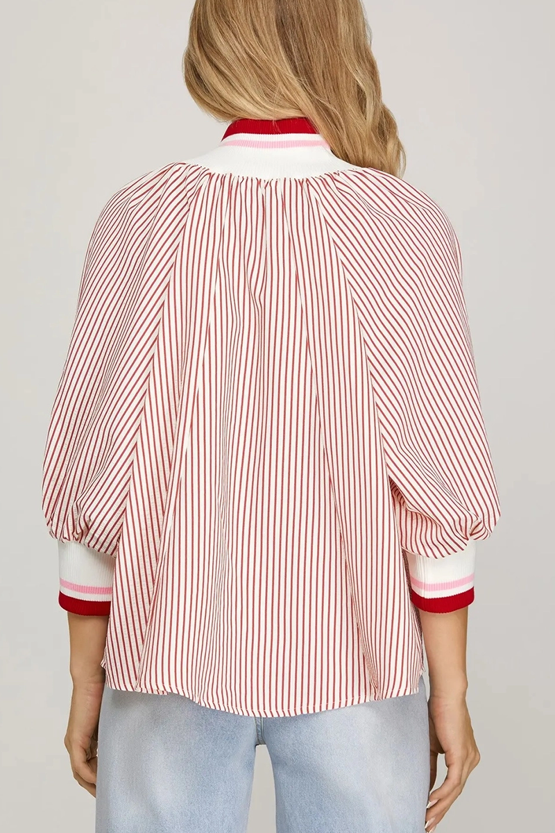 Woman wearing a red and white striped shirt with a plain background