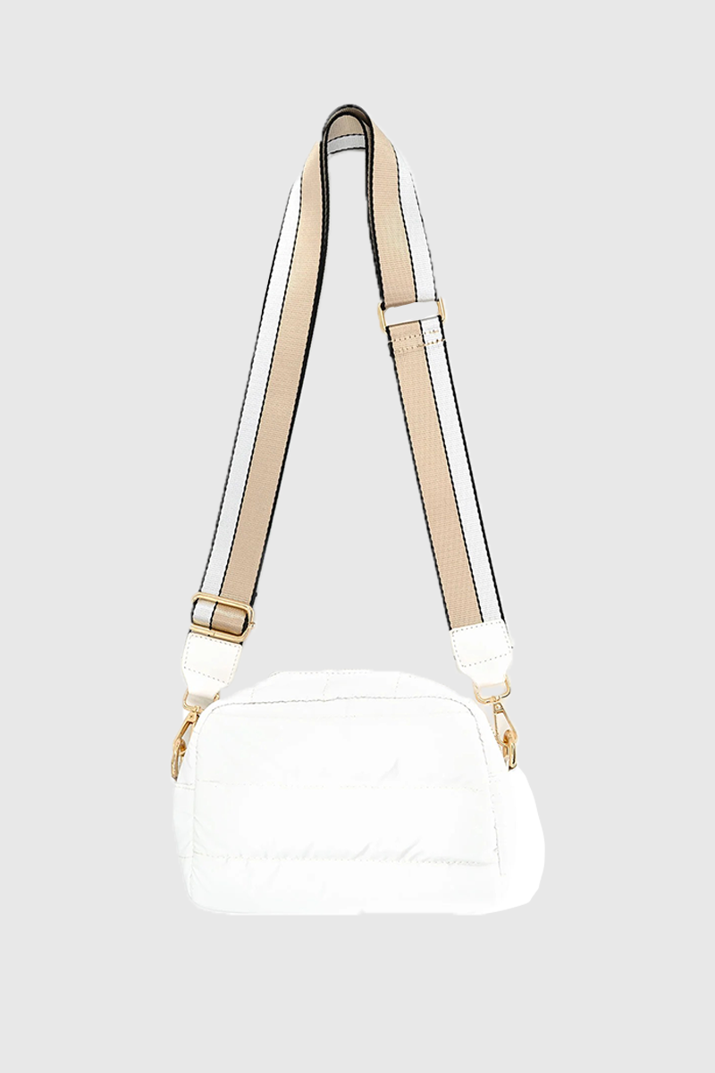 White handbag with beige strap on a light gray background