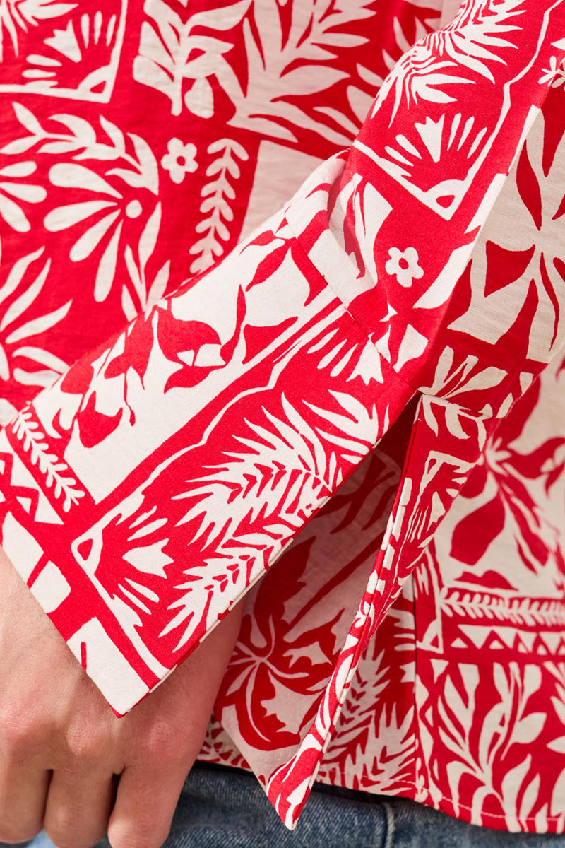 Red and white patterned fabric with a hand holding it