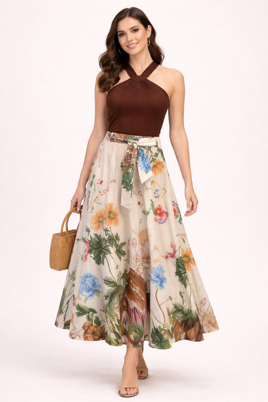 Woman wearing a brown top and floral skirt with a beige background