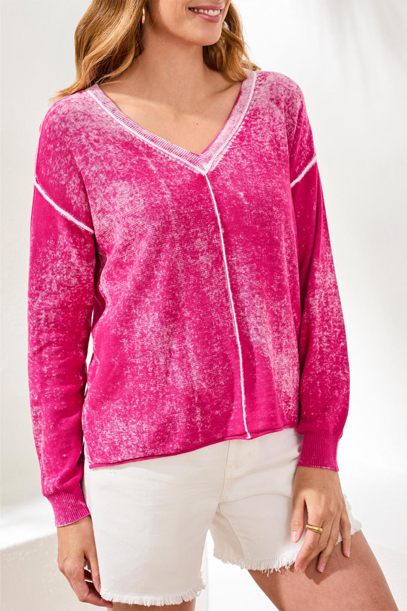 Woman wearing a pink long-sleeve top with white trim on a white background