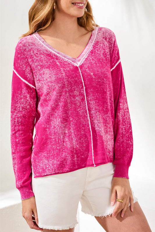 Woman wearing a pink long-sleeve top with white trim on a white background