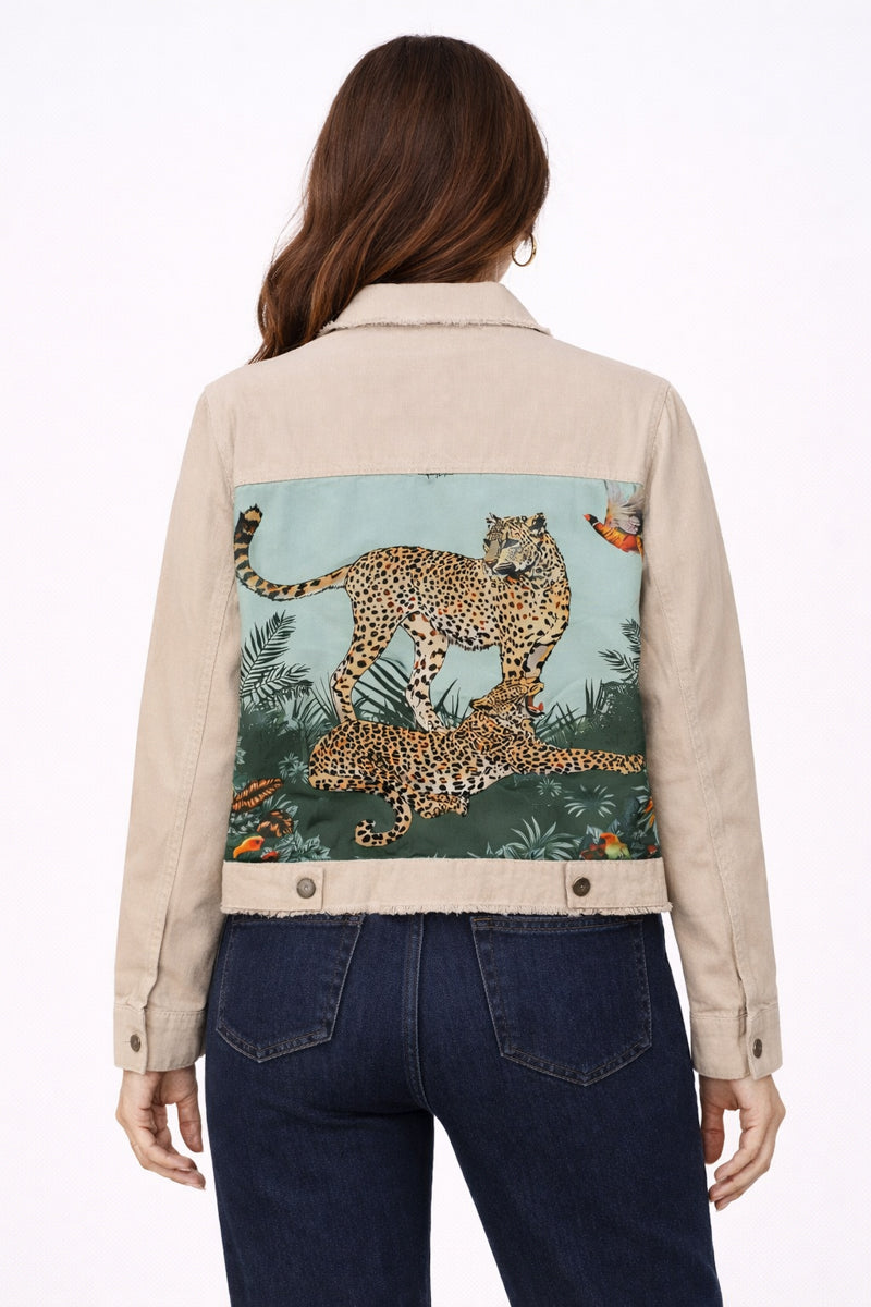Beige denim jacket with leopard design on the back, worn by a person.