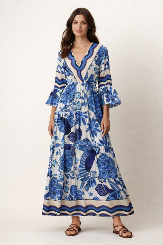 Woman wearing a blue and white floral dress on a plain background