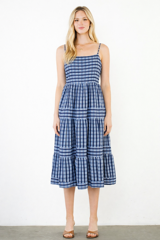 Woman wearing a blue gingham dress against a white background