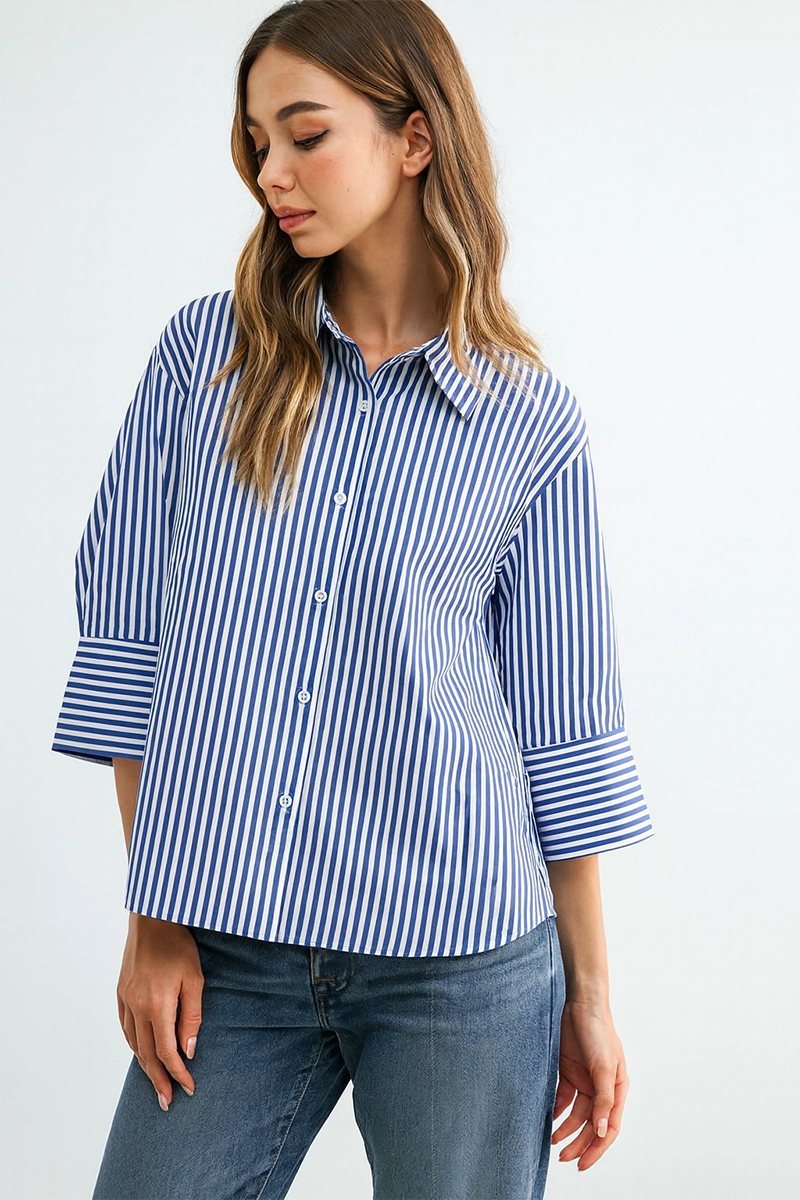 Woman wearing a blue and white striped shirt with rolled-up sleeves on a white background