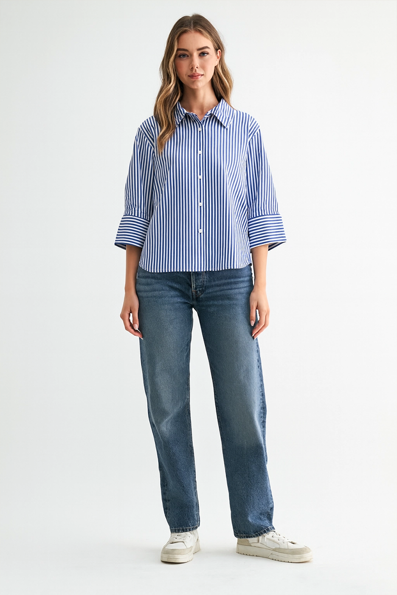 Woman wearing a blue and white striped shirt and jeans on a white background