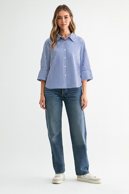Woman wearing a blue and white striped shirt and jeans on a white background