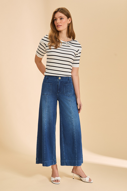 Woman wearing a striped shirt and blue jeans on a beige background