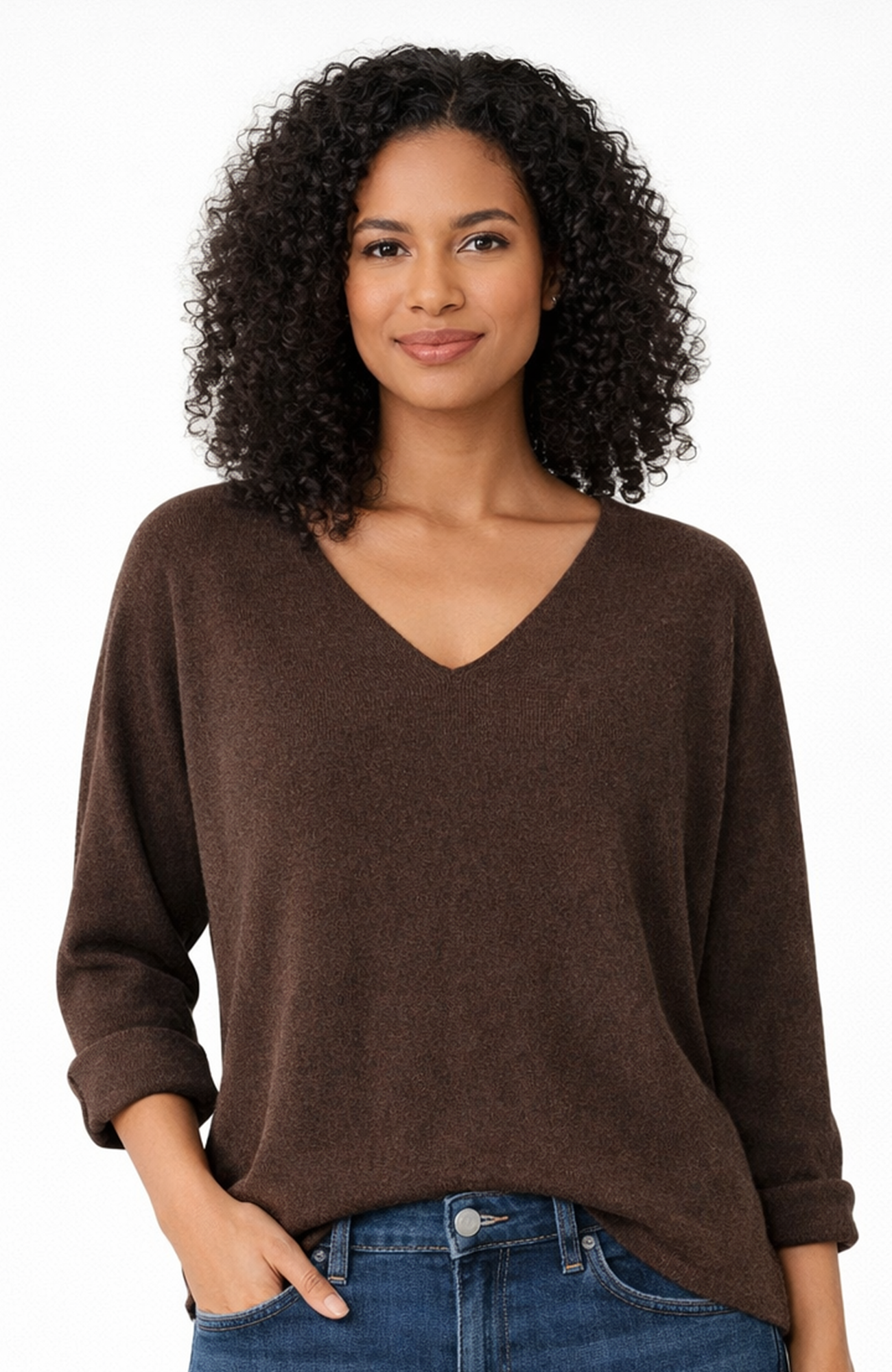 Woman wearing a brown sweater and blue jeans on a white background
