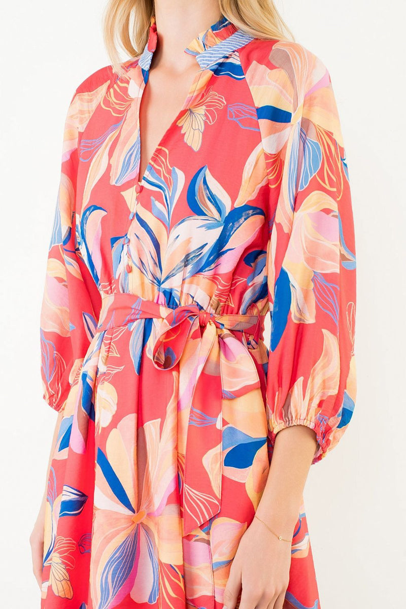 Colorful floral-patterned dress worn by a person on a white background