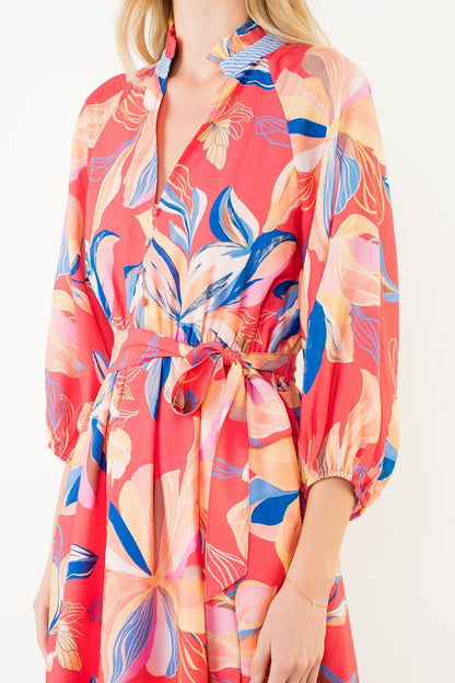 Colorful floral-patterned dress worn by a person on a white background