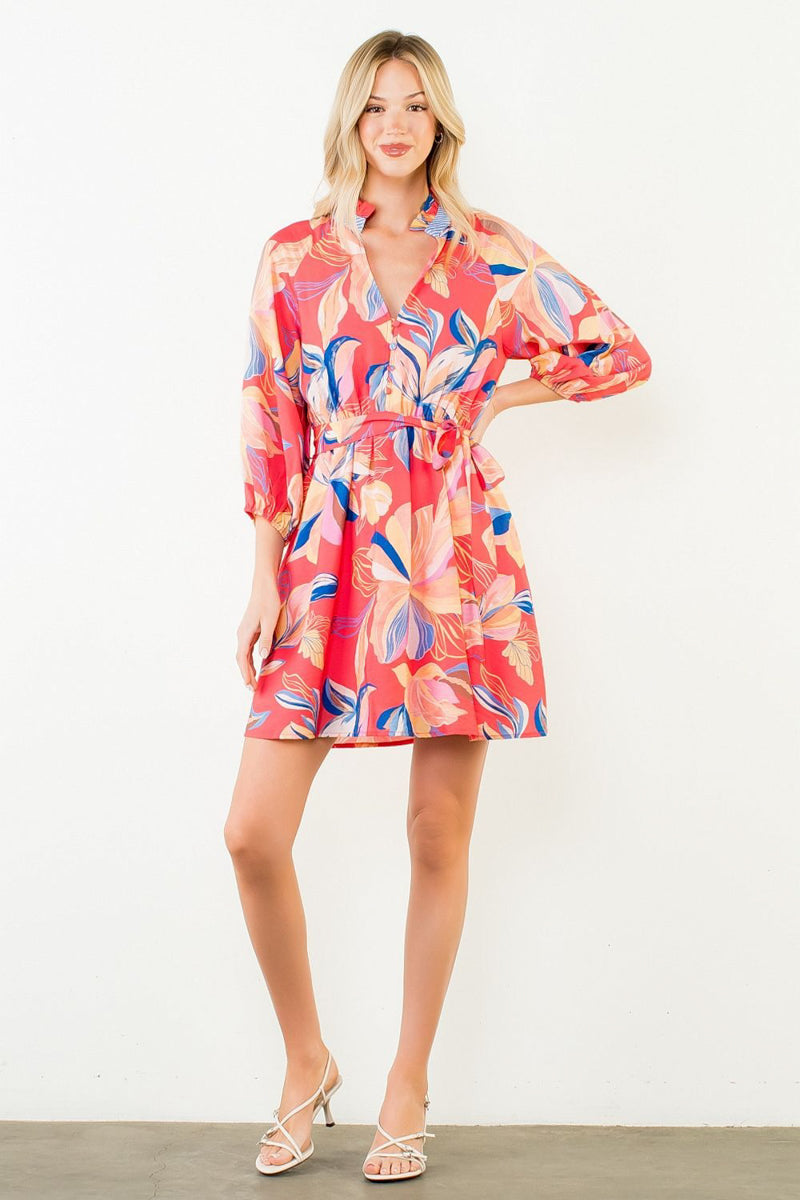 Woman wearing a colorful floral dress against a white background