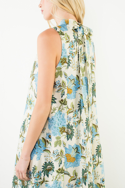 Woman wearing a sleeveless floral dress with a white background