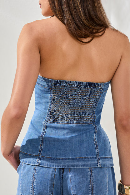 Blue strapless denim strapless top and pants worn by a person on a plain background