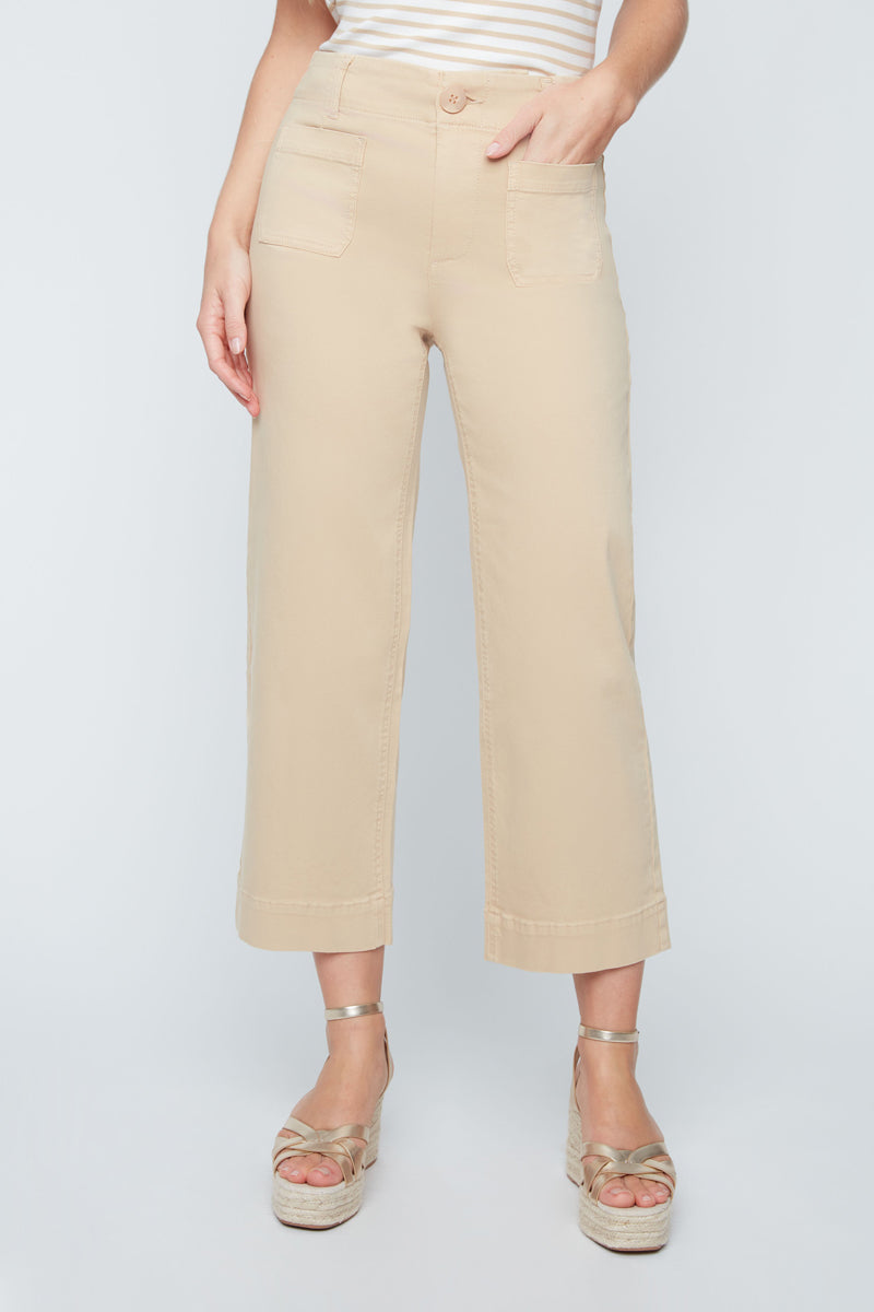Person wearing beige pants and sandals on a white background