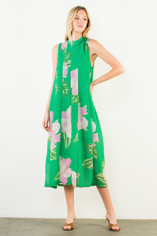 Woman wearing a green dress with floral patterns on a white background