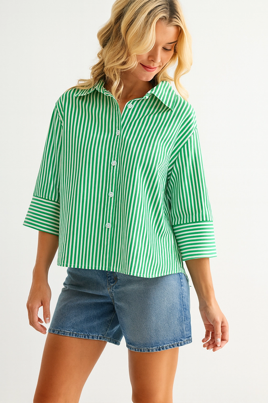 Woman wearing a green and white striped shirt with denim shorts on a white background