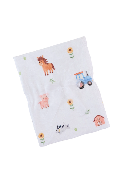 Baby blanket with farm animal and vehicle illustrations on a white background
