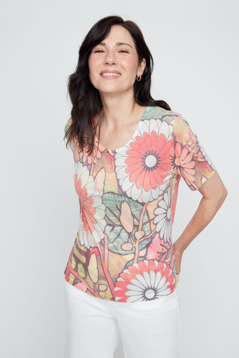 Woman wearing a colorful floral-patterned shirt against a white background