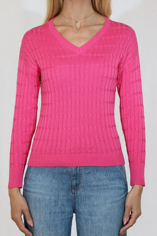 Person wearing a bright pink sweater and blue jeans on a plain background