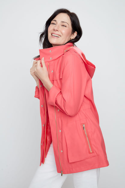 Woman wearing a coral raincoat on a white background