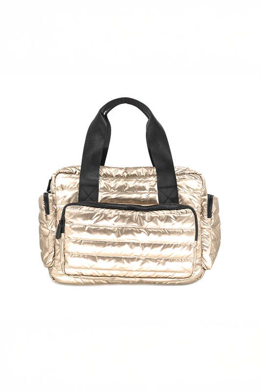 Gold quilted handbag with black straps on a white background