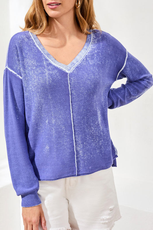 Woman wearing a blue distressed sweater on a white background