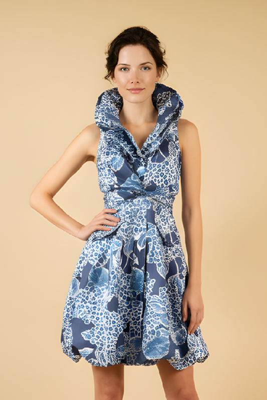 Woman wearing a blue floral dress against a beige background