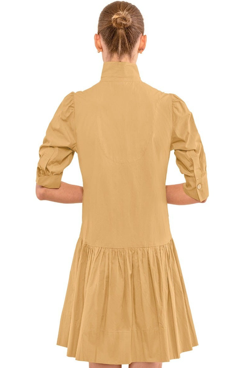 Woman wearing a beige dress with long sleeves on a white background