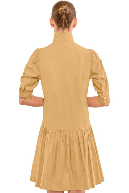 Woman wearing a beige dress with long sleeves on a white background