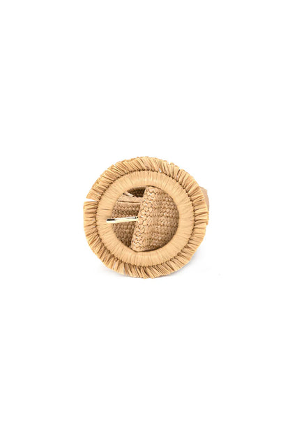 Khaki colored belt rolled up with a circle buckle that has fringe around it