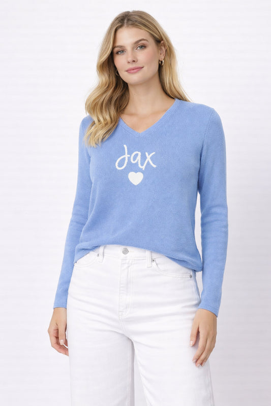 Woman wearing a blue sweater with 'jax' and a heart on a white background
