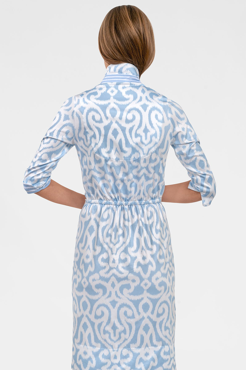 Woman wearing a blue and white patterned dress on a white background