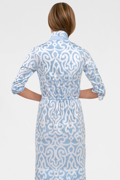 Woman wearing a blue and white patterned dress on a white background