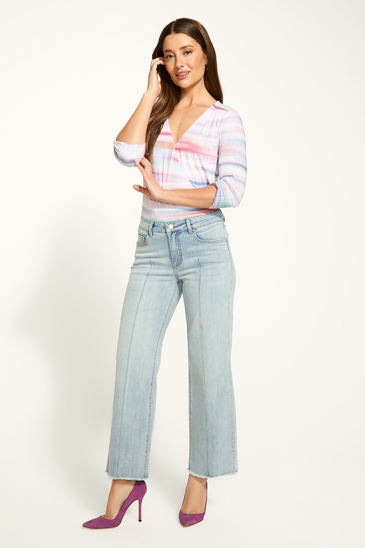 Woman wearing a striped shirt and light blue jeans on a white background