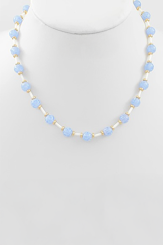 Necklace with light blue beads on a mannequin against a white background