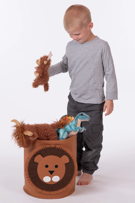Child playing with stuffed animals in a lion-shaped toy box on a white background