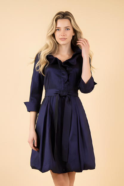 Woman wearing a navy blue dress against a beige background
