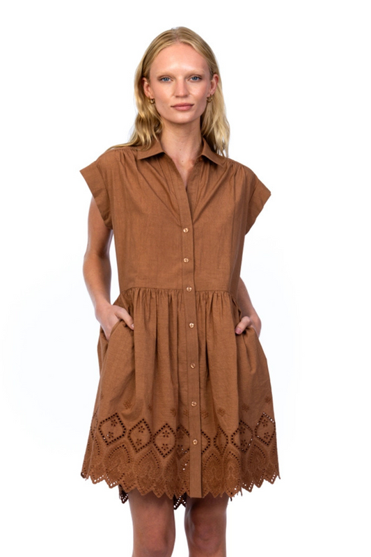 Woman wearing a brown dress with lace details on a white background